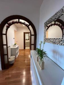 a living room with an archway with a sink and a mirror at Attico con vista panoramica in Vitinia