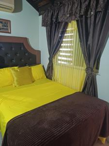 ein Schlafzimmer mit einem gelben Bett und einem Fenster in der Unterkunft Barbican cozy Flat at dillsbury in Kingston