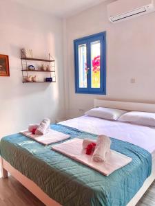 a bedroom with a bed with towels on it at Elitas Lodge: Cosy Cycladic home outside Paroikia in Kampos Paros