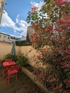 une chaise rouge et une table sur une terrasse dans l'établissement Maison Luxe avec Jardin, 5 Chambres, Home Cinéma - Métro 1, à Vincennes