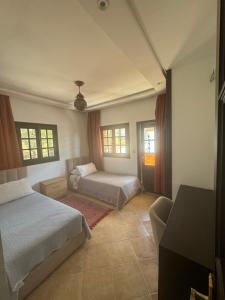 um quarto com 2 camas, um sofá e janelas em Mina House em Chefchaouen