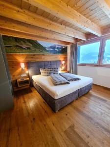 1 dormitorio con 1 cama grande y techo de madera en Alpenzeit, en Ladis