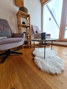 uma sala de estar com um sofá, uma mesa e um tapete branco em Alpenzeit em Ladis