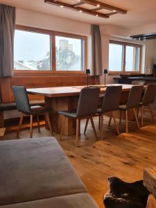 uma sala de jantar com uma grande mesa e cadeiras em Alpenzeit em Ladis