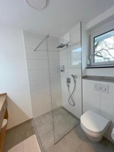 ein Bad mit einer Dusche und einem WC in der Unterkunft MEIN MOTEL - Self Check-in 