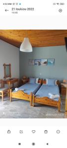 a bedroom with two twin beds and a table at Studios Maro in Skala Kallonis