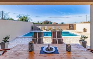 a patio with a table and a swimming pool at Gorgeous Home In Vodnjan With Wifi in Vodnjan +29 photos