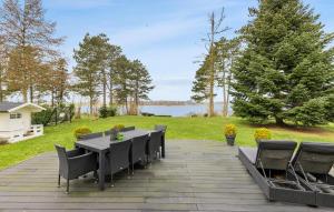 un patio con mesa, sillas y un lago en Amazing Home In Roskilde With Kitchen en Roskilde