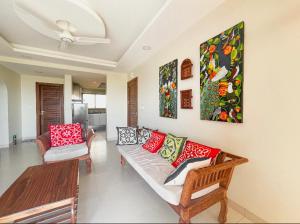 a living room with a couch and paintings on the wall at Best View Malindi Guest House in Mwembe Maepe