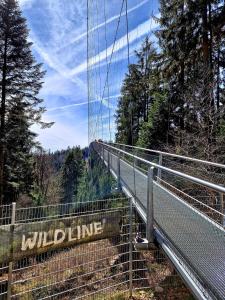 Eine Brücke mit einem Schild, auf dem Wildnis steht. in der Unterkunft Aparthotel Schwarzwald Panorama in Bad Wildbad