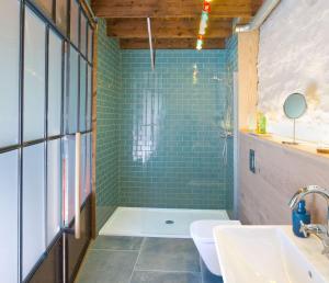 a bathroom with a shower with green tiles at Le Moulin du Mottay in Évran