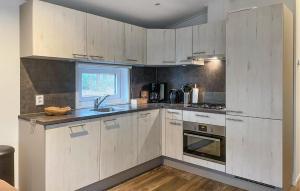 a kitchen with white cabinets and a sink at Pet Friendly stacaravan In Hardenberg With Kitchen in Hardenberg