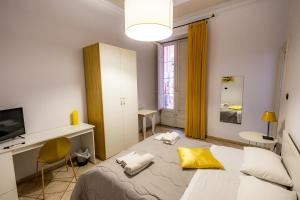 a bedroom with a bed and a desk and a window at Promenade B&B in Catania