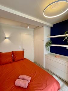 Un dormitorio con una cama con una manta naranja. en Comme une chambre d’hôtel au cœur de Lyon, en Lyon 17 fotos más