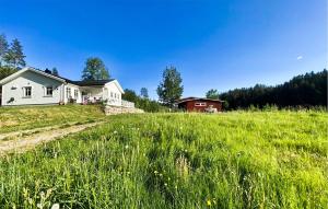 una casa blanca en un campo de hierba alta en Amazing Home In Lunde With House A Panoramic View en Lunde
