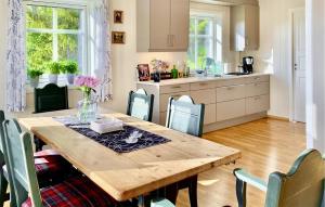 eine Küche und ein Esszimmer mit einem Holztisch und Stühlen in der Unterkunft Amazing Home In Lunde With House A Panoramic View in Lunde