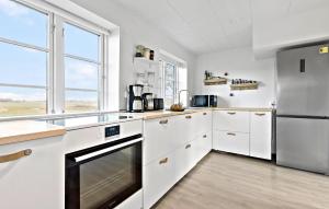 a kitchen with white cabinets and a stainless steel refrigerator at Amazing Home In Skibby With Kitchen in Skibby