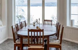 a dining room with a wooden table and chairs at Nice Home In Hunge With House Sea View in Bräcke