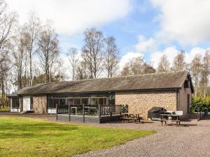 a brick building with a grill and picnic tables at Saffron in Banchory