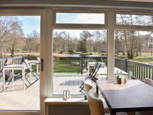 a screened porch with a view of a lake at Saffron in Banchory