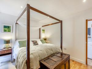 a bedroom with a four poster bed and a tub at Midsummer Cottage Retreat in Pilton