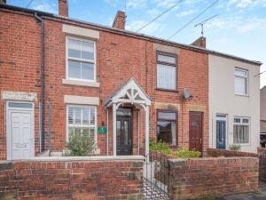 a red brick house with a white door at Ivy Cottage in Belper