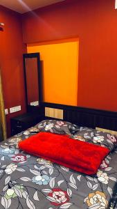 una manta roja en una cama en un dormitorio en Shivas Farmhouse, en Sultan Bathery
