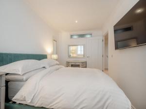 een witte slaapkamer met een bed en een raam bij Luxury Moffat Apartment in Moffat