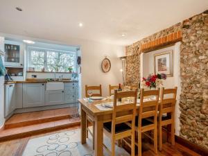 eine Küche und ein Esszimmer mit einem Holztisch und Stühlen in der Unterkunft Little Crawfish Cottage in Thursford