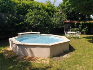 een hot tub in de tuin met een tafel en stoelen bij Au Ruisseau de Rose in Saint-Jean-du-Gard