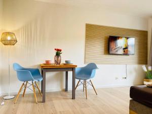 a living room with a table and two blue chairs at BERGflair inkl. Oberstaufen PLUS in Oberstaufen