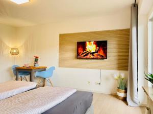 a bedroom with two beds and a fire on the wall at BERGflair inkl. Oberstaufen PLUS in Oberstaufen