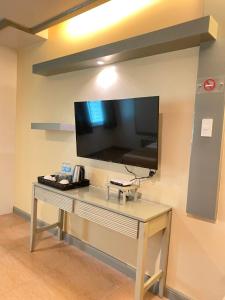 a room with a desk with a tv on a wall at La Piazza Hotel and Convention Center Inc. in Legazpi