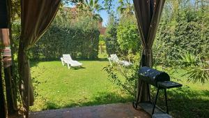 uitzicht op een tuin met een bank in de tuin bij atlas golf resort marrakech " Maison à 03 chambres avec jardin privé " in Marrakesh