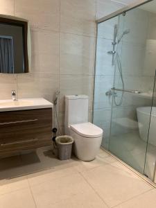 y baño con aseo, ducha y lavamanos. en Saraya Al Olaya Tower family house en Al Khobar