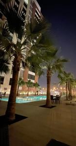 un gruppo di palme su una spiaggia di notte di Saraya Al Olaya Tower family house a Al Khobar