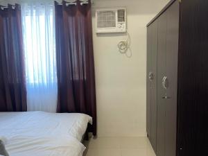 a bedroom with a bed and a window with a air conditioner at Jazz Residences Makati City by darpm in Manila +15 photos
