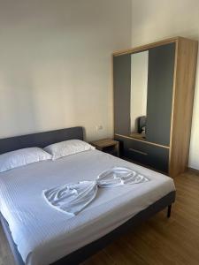 een slaapkamer met een bed en een badjas. bij Vlora Central & Comfy Apartment in Vlorë