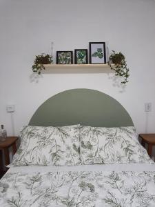 a bedroom with a bed with three pictures on the wall at Casa Groot in Holambra