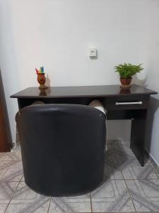 un escritorio negro con una silla de oficina negra con una planta en Casa Groot, en Holambra 6 fotos más