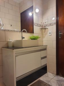 uma casa de banho com um lavatório e um espelho em Casa Groot em Holambra