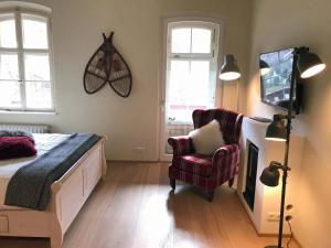 a bedroom with a bed and a chair and a tv at ciao-aschau Haus zur Burg Ap204 Hupferl1 in Aschau