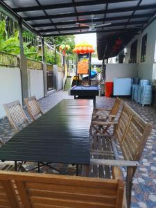 un patio con grande tavolo e sedie in legno di 15PAX 3BR Villa E2,Kids Swimming Pool, Pool Table n BBQ near SPICE Arena Penang a Bayan Lepas