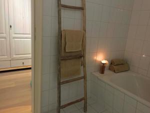 a bathroom with a bath tub and a towel rack at ciao-aschau Haus zur Burg Ap204 Hupferl1 in Aschau +11 photos