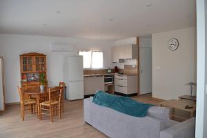 a living room with a couch and a table and a kitchen at Aux abords de la forêt in Fougeré