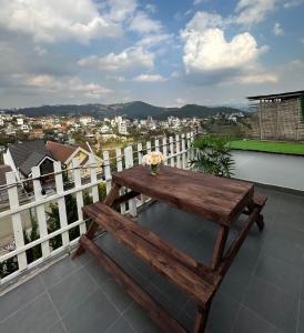 a wooden bench sitting on top of a balcony at La Mer House Đà Lạt in Ấp Ða Lợi