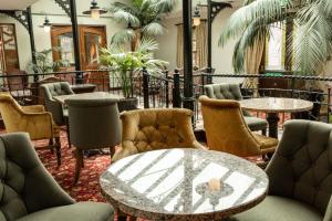 um átrio com mesas, cadeiras e palmeiras em Kee's Hotel em Stranorlar