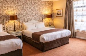 um quarto de hotel com duas camas e uma janela em Kee's Hotel em Stranorlar