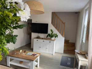 a living room with a tv and a table at La Petite Maison in Vermand