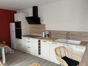 a kitchen with white cabinets and a counter with a sink at La Petite Maison in Vermand